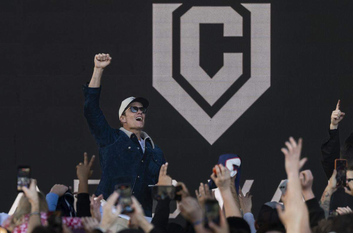 Seven-time Super Bowl champion Tom Brady cheers on the crowd during a rally for the newly opened CardVault store in Downtown Commons on Thursday.