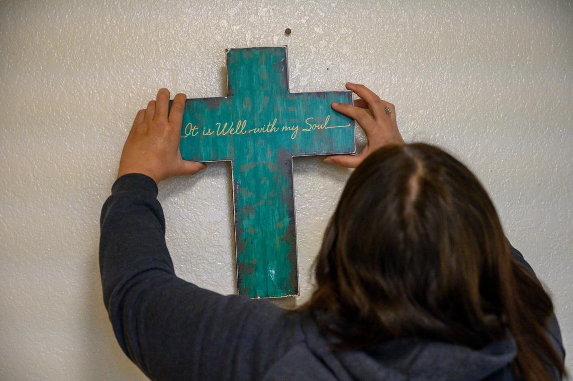 Carreen Huizar, 50, hangs a decoration Monday, Jan. 20, 2020, on the wall of the Sacramento apartment she rented with a Section 8 voucher. Hulzar, who was homeless and had no furnishings, said she is very grateful to the people who donated furniture and decorations for the apartment thorough a website.