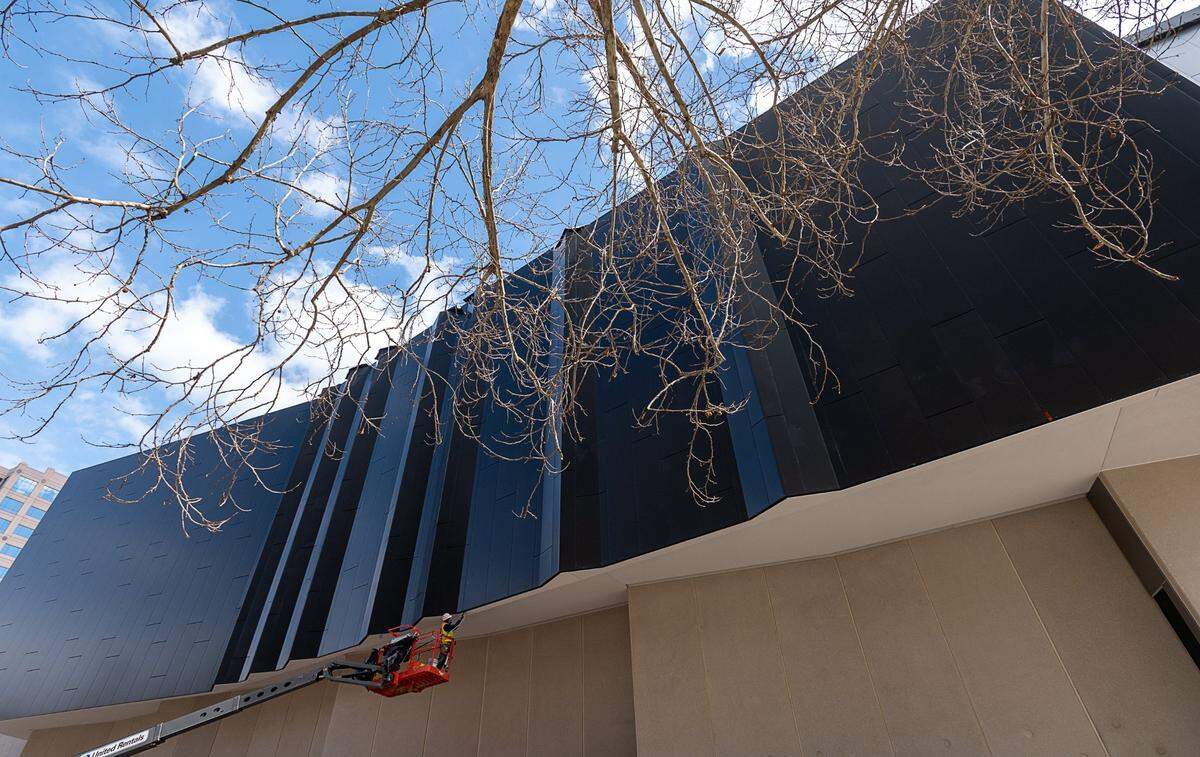 A worker puts finishing touches on the new exterior for the Sacramento Convention Center on Monday. The $245 million project is the second major remodel for the center, which was first built in 1974.