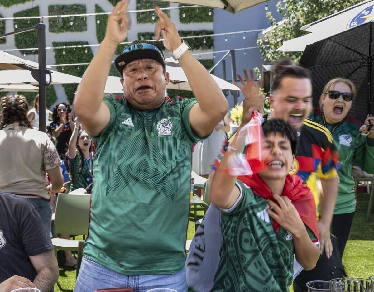 Cesar Luna and his nephew Jovany cheer on Mexico during at the start of its World Cup soccer match against South Africa during a watch party at Garden at the Line in Sacramento on Thursday.