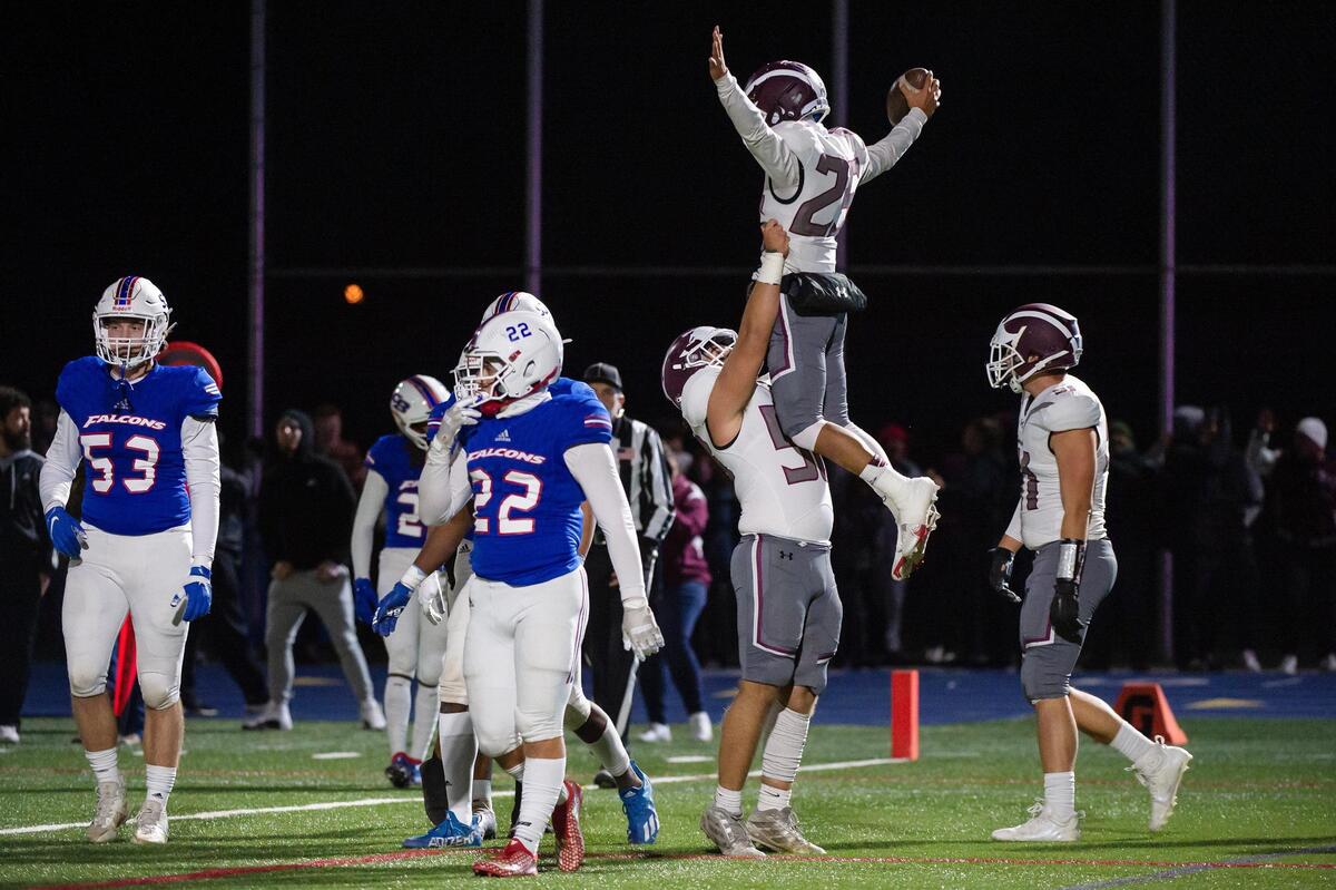 Woodcreek’s Alexander Gonzalez (58) lifts running back Caleb Panlilio (25) after he scored a touchdown during the first half in the CIF Sac-Joaquin Division III semifinal playoff game Friday, Nov. 18, 2022, at Christian Brothers High School in Sacramento.
