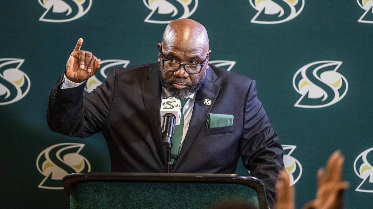 New Sacramento State football coach Alonzo Carter makes the "stingers up" gesture as he speaks during his introductory news conference on Thursday, Dec. 18.