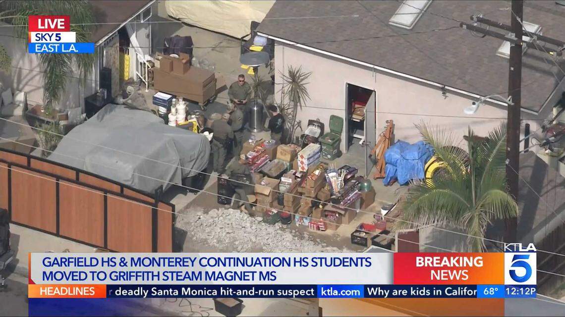 An image of video taken from KTLA's helicopter on Monday, Oct. 27, 2025, shows investigators inspecting boxes of fireworks at a home in East Los Angeles. Authorities say the raid was connected to the investigation of the July 1 explosion and fire at a fireworks warehouse in Esparto.