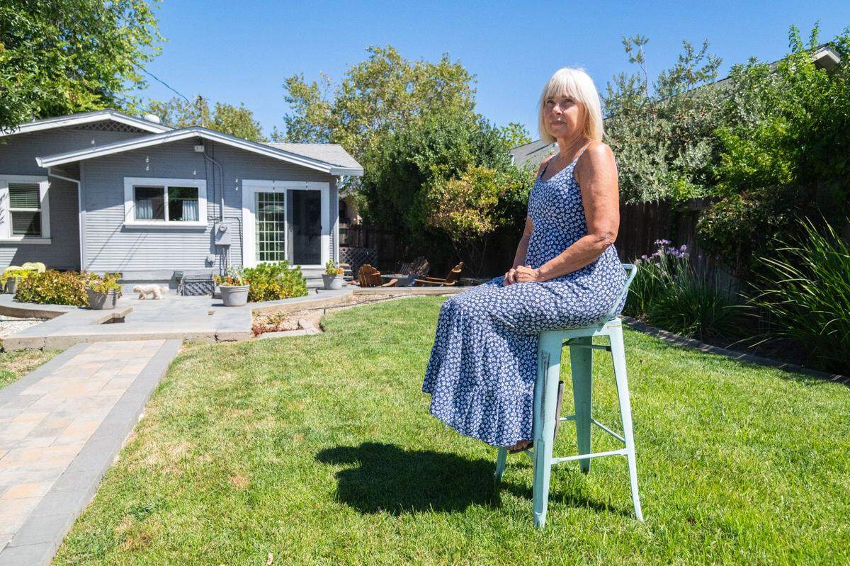 Jan Truelock sits where she plans to build an accessory dwelling unit in her backyard in Roseville on Wednesday, Aug. 14. Truelock has selected a new ADU builder after her experience ADU with Anchored Tiny Homes. “You just really have to do your work and make sure that you’re getting a company to build your ADU that is on the up and up,” she said.