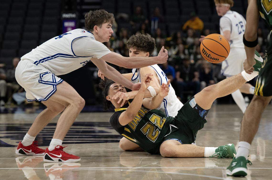 The Damien Spartans' Sammy Franco (22) passes the ball as the Folsom Bulldogs' Jack Shull (4) and Kellen Garcia (20) defend in the second half in the CIF State Division I boys basketball championship Friday at Golden 1 Center.