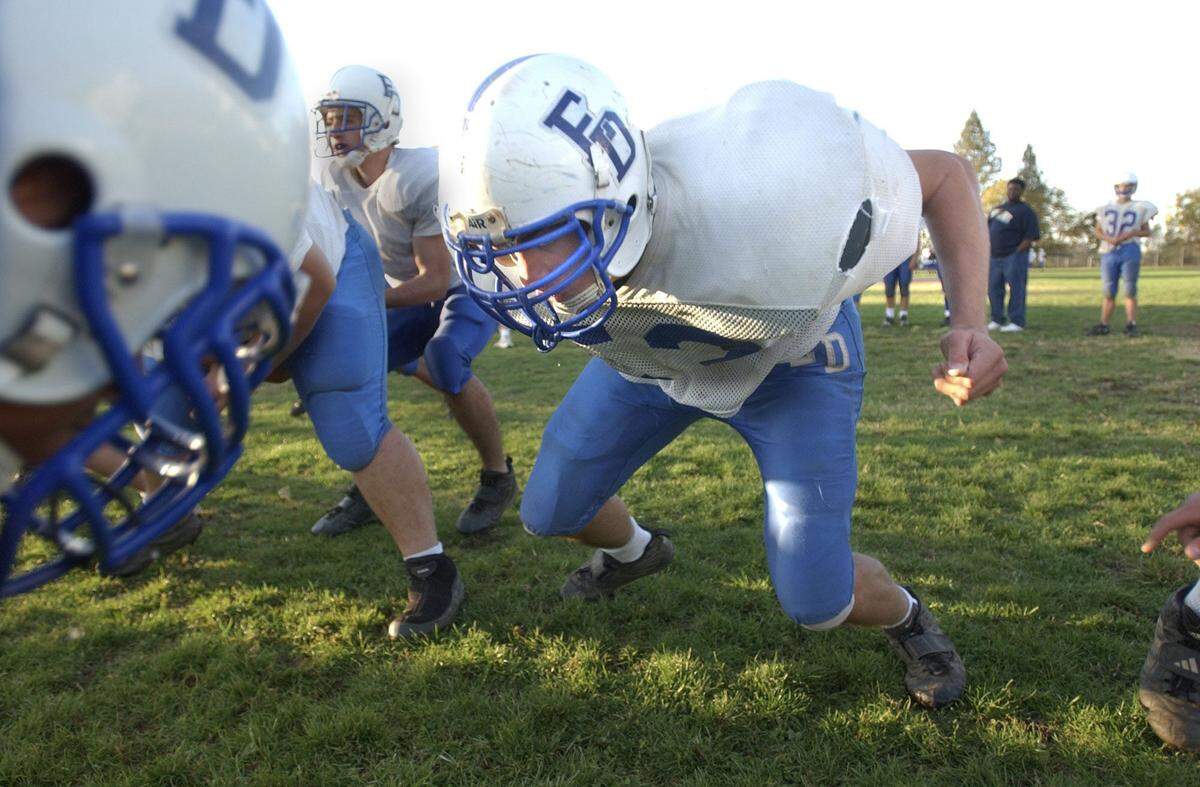 El Dorado High School players participate in a full-contact practice in Placerville in 2002. These days, many teams minimize the amount of tackling in the preseason.