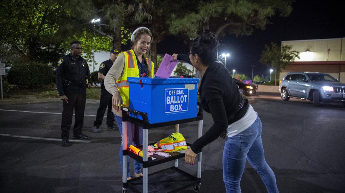 Megan Hogge works the drive thru ballot box in the parking lot of the Voter Registration and Elections office in Sacramento before the polls closed on Tuesday night, November 6, 2018.