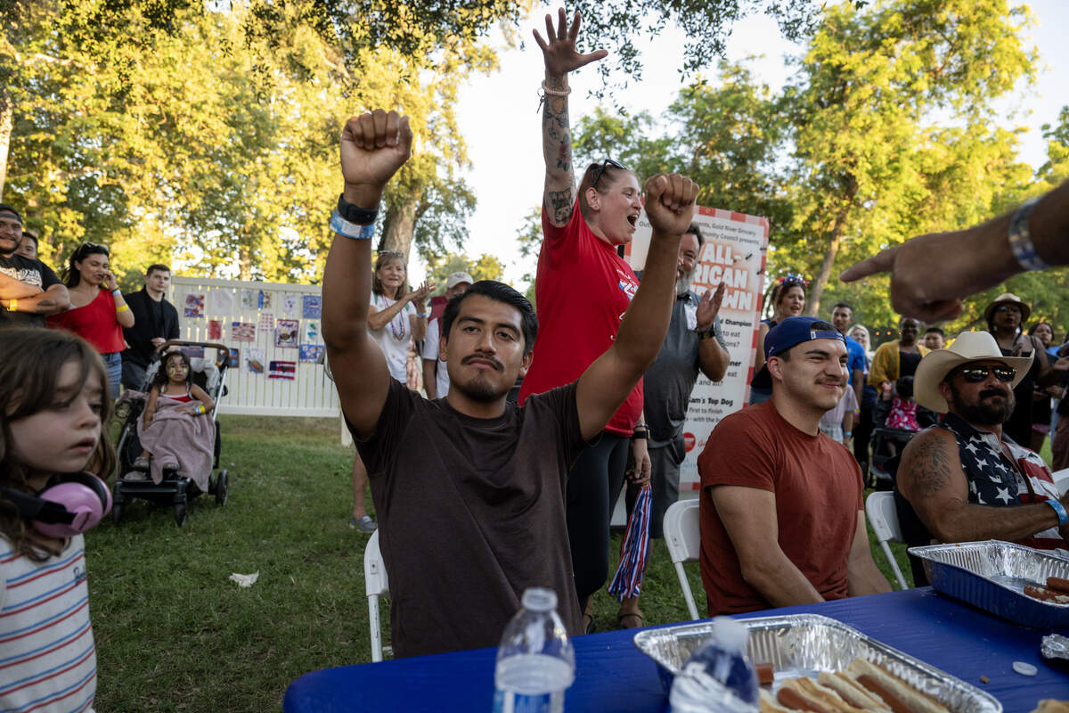 Miguel Vasquez raises his arms in celebration after eating 16 1/2 hot dogs during a hot dog eating contest at the Fourth of July celebration at Hagan Community Park in Rancho Cordova on Friday, July 3, 2026.