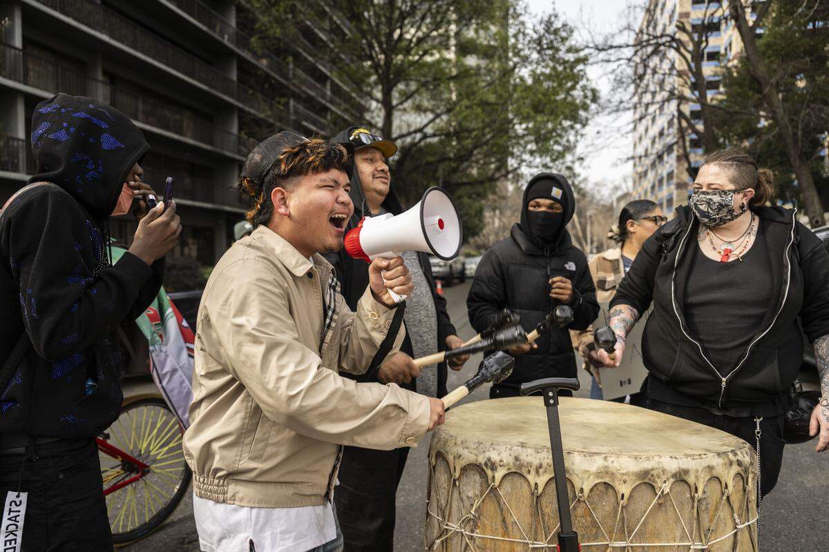 Mark Jhohann, a Burbank High School student, plays a drum and chants during a student-led protest against ICE behind the John E. Moss Federal Building on Friday. The students marched from the Capitol to support a group regularly protesting against detentions at the building. 