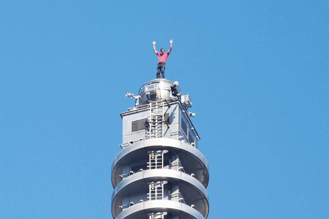 TOPSHOT - US rock climber Alex Honnold raises his arms from the top of the Taipei 101 building after he successfully free soloed the landmark skyscraper without ropes or safety gear in Taipei on January 25, 2026. (Photo by I-HWA CHENG / AFP via Getty Images)