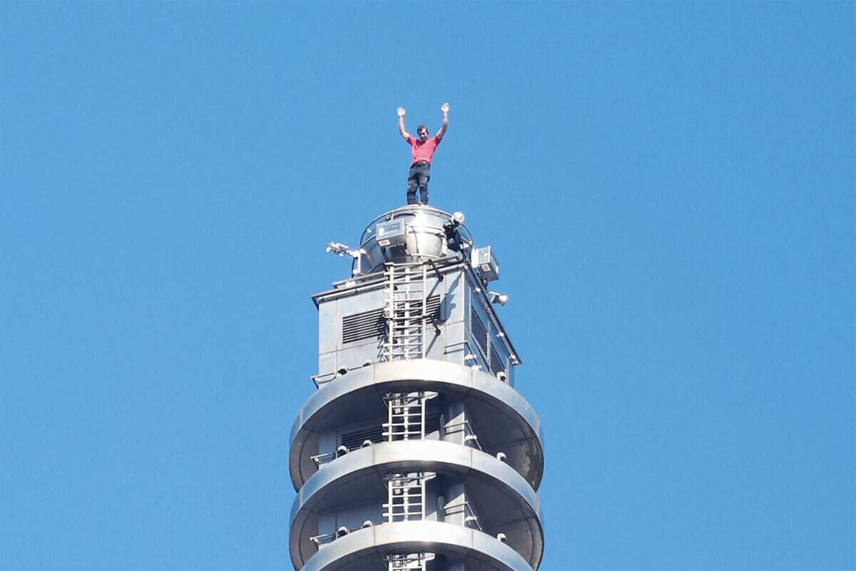 TOPSHOT - US rock climber Alex Honnold raises his arms from the top of the Taipei 101 building after he successfully free soloed the landmark skyscraper without ropes or safety gear in Taipei on January 25, 2026. (Photo by I-HWA CHENG / AFP via Getty Images)