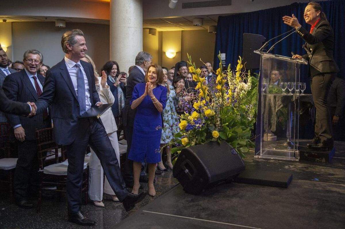 Eleni Kounalakis, right, jokes with Gov. Gavin Newsom, left, as U.S. House Speaker Nancy Pelosi, center, cheers them after Kounalakis was sworn in as lieutenant governor at the Tsakopoulos Library Galleria in Sacramento on Jan. 7, 2019.