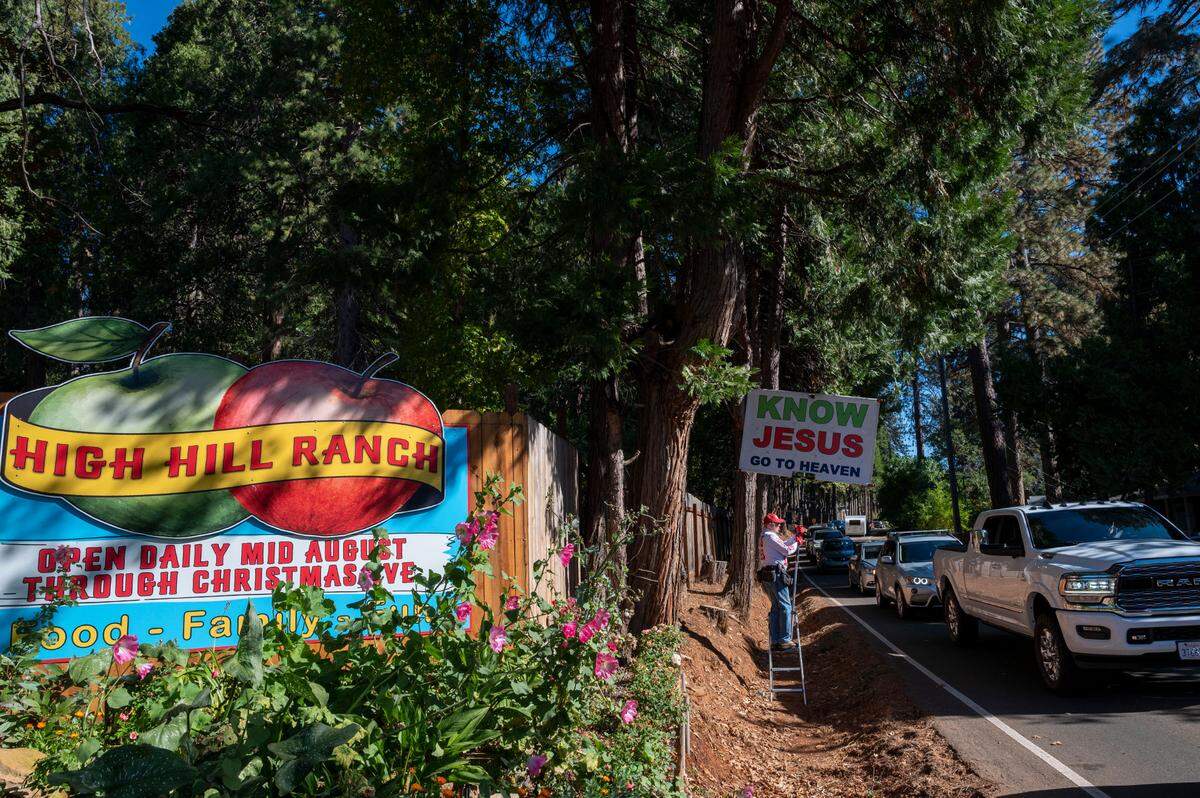 A man who goes by “Gospel Gary” takes advantage of the slow-moving traffic on Carson Road in front of High Hill Ranch, to preach Saturday at Apple Hill.