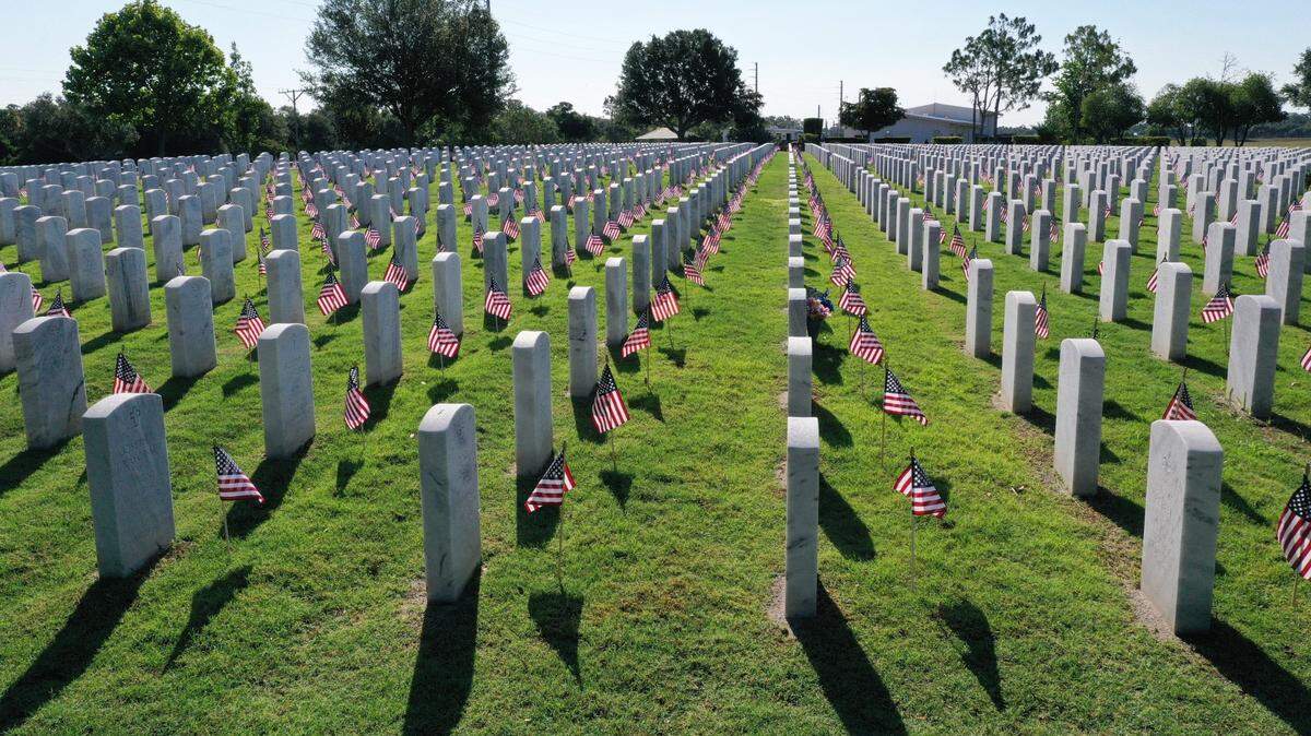 Nearly 1,000 volunteers with Wreaths Across America placed 24,000 flags on the graves of veterans at Sarasota National Cemetery in the ninth annual flag placement ceremony Saturday morning, May 25, as a part of the Memorial Day commemoration. Volunteers placed American flags on each grave, exactly 12 inches from the center of the headstone before stating the veteran's name and saluting. The 12-inch distance signifies the length of the boot of members of the Old Guard at Arlington National Cemetery. For more information visit sarasotawreaths.com for how to volunteer or donate.