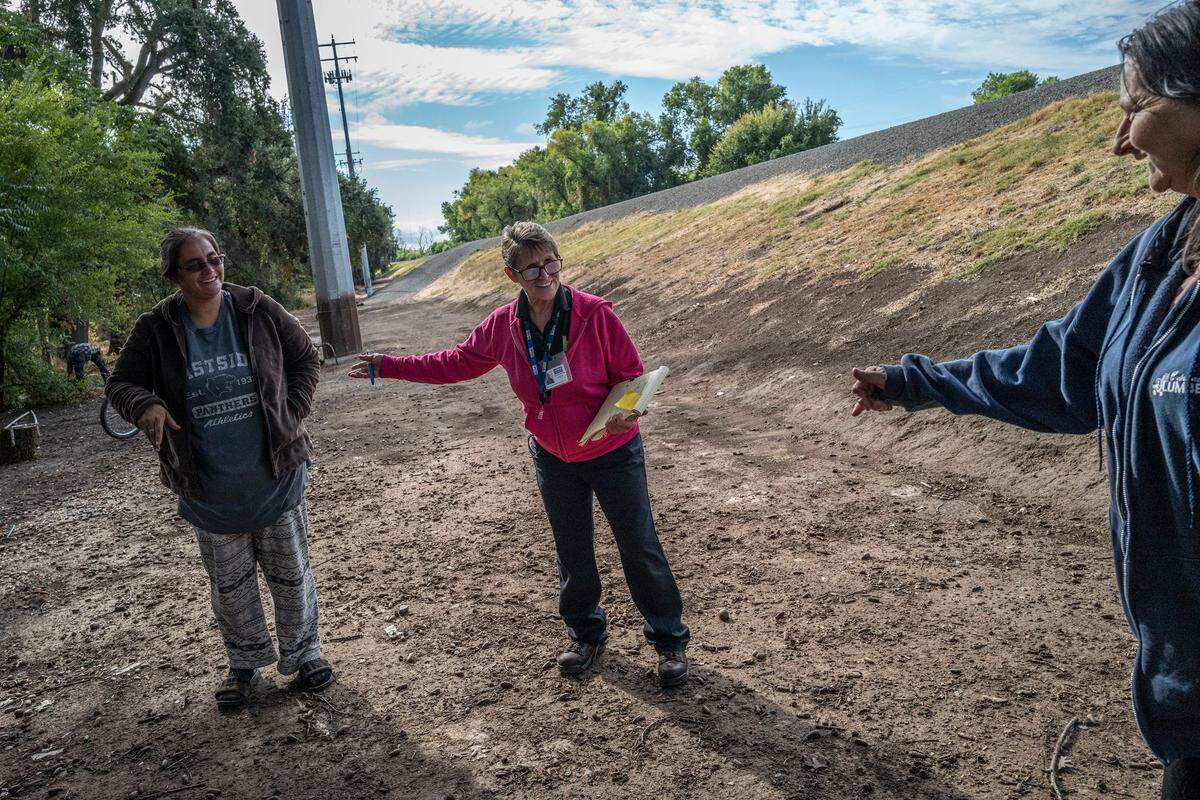While working as a case manager for Hope Cooperative, Tracey Knickerbocker, center, introduces homeless neighbors Alley Thut, left, and Lily Marshall last month, near where she used to camp under the 12th Street bridge when she was homeless herself in Sacramento.