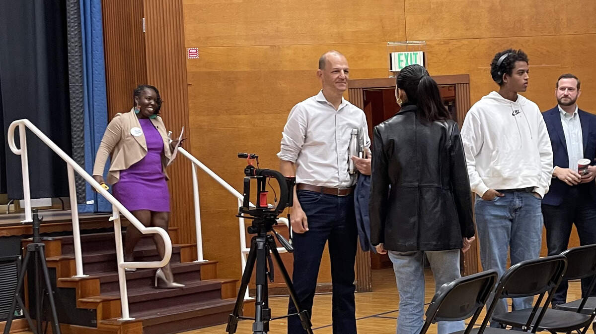 Flojaune Cofer descends the stairs as Kevin McCarty, center, and Steve Hansen, right, speak with supporters at a Sacramento NAACP mayoral candidates forum on Saturday, Nov. 11, 2023.