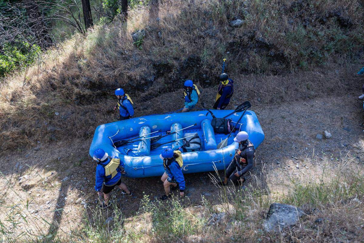 Sam Almeida, a guide with Action Whitewater, bottom right, helps his group carry their raft to the Oxbow put-in site near the Middle Fork of the American River on Sunday, June 2, 2024.