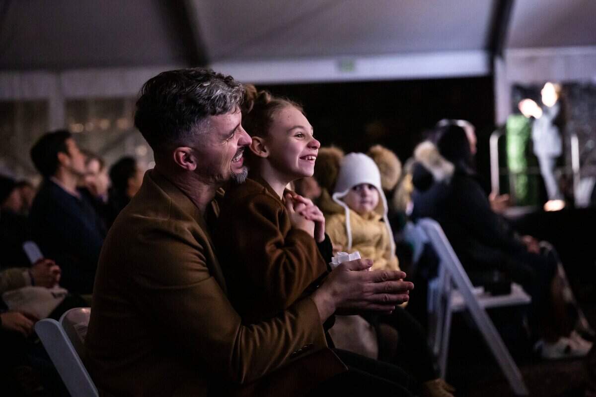 Alex Datskyy holds his 8-year-old daughter Layla, the official 2022 state Capitol tree lighter, as she enjoys the 91st annual state Capitol tree lighting ceremony on Thursday, Dec. 1, 2022. The Fair Oaks family moved from Ukraine about eight years ago, Datskyy said. His parents, who still live in Ukraine, had a bomb fall near their house. “Every day looks so scary,” he said. “We just pray.”