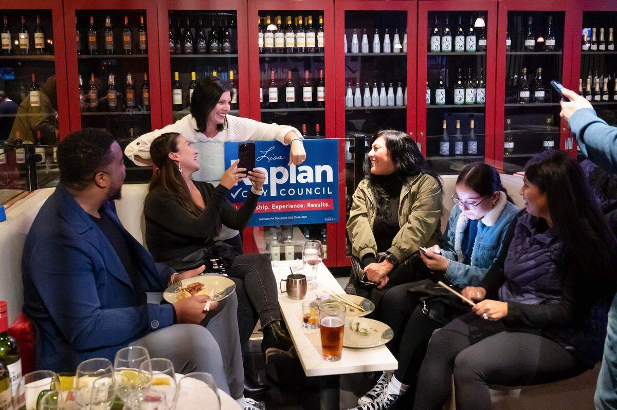 Lisa Kaplan, leaning on sign, visits with her City Council campaign supporters and staff at an election night party at Oshima Sushi in Natomas on Tuesday, Nov. 8, 2022.