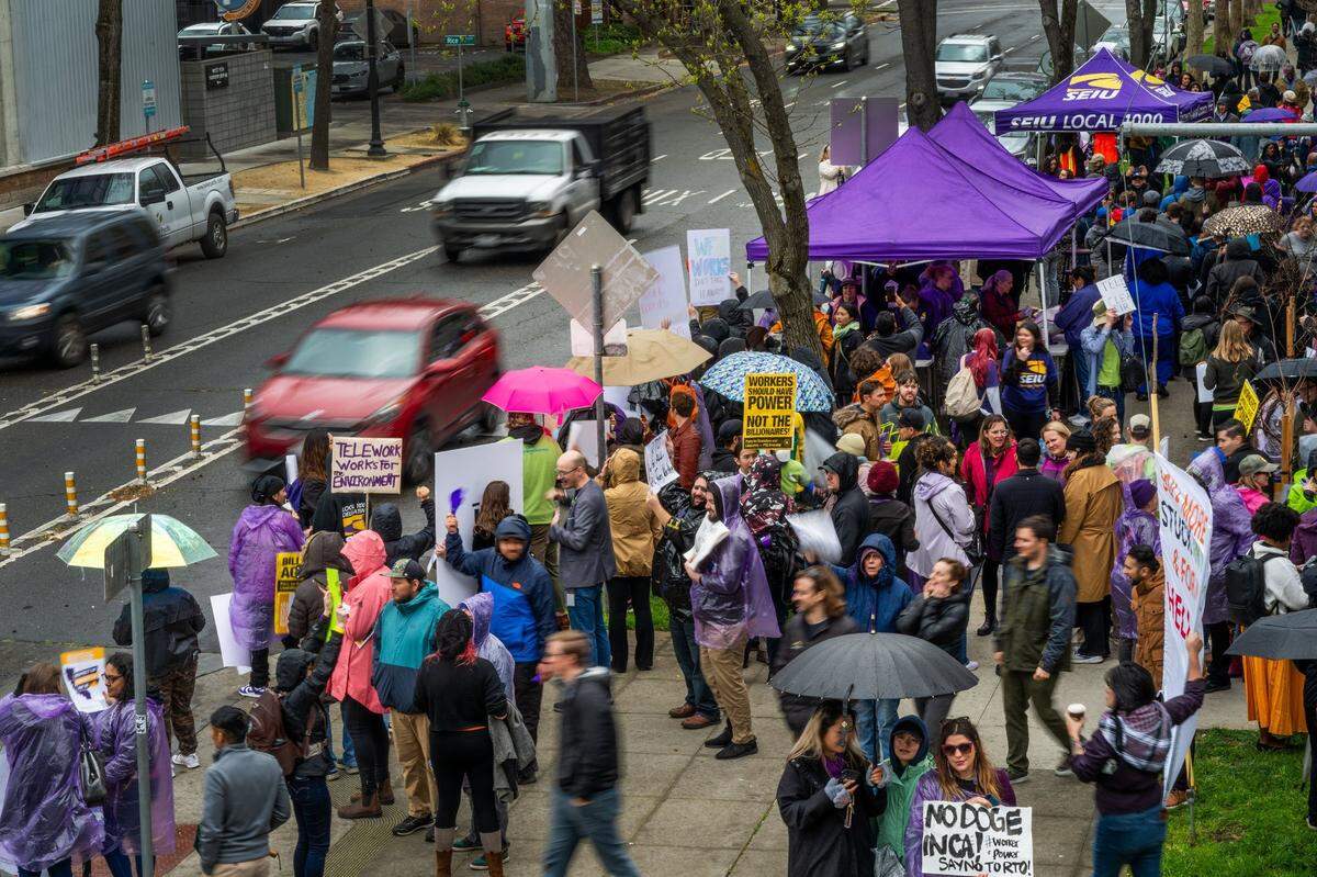 Hundreds of state workers hold signs outside the CalHR offices in Sacramento on Wednesday.