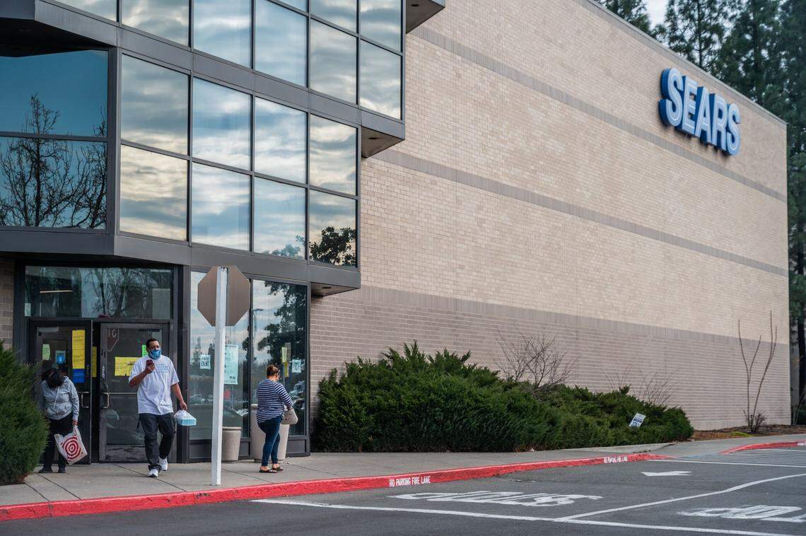 Masked customers walk outside of Sears at Arden Fair mall in Sacramento on Monday, Feb. 1, 2021.