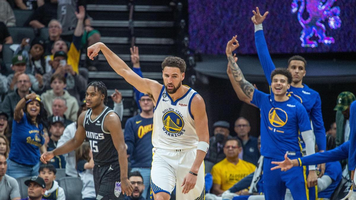 Golden State Warriors guard Klay Thompson (11) and his teammates celebrate a three point basket as Sacramento Kings guard Davion Mitchell (15) stands dejected during an NBA game between the Sacramento Kings and the Golden State Warriors on Friday, April, 7, 2023 at Golden 1 Center. Thompson finished with a game high 29 points during the Warriors 119 to 97 victory.