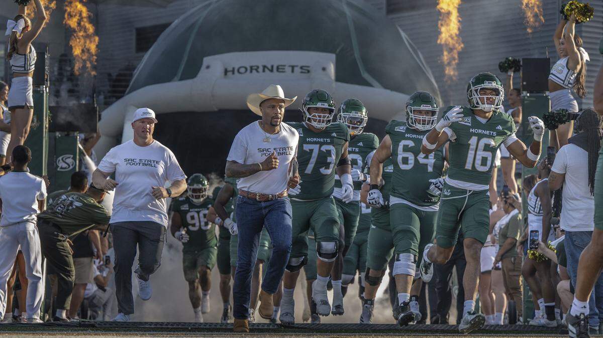 Sacramento State Hornets head coach Brennan Marion, center, runs onto the field before an NCAA football game against the Mercyhurst Lakers at Hornet Stadium on Saturday, Sept. 13, 2025.