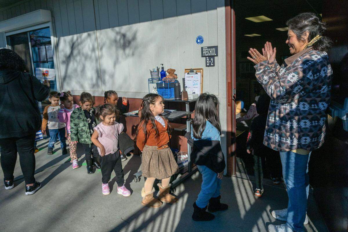 Teacher Dometila Casillas sings and claps as she says each child’s name while she ushers them back into the classroom after recess during a Head Start preschool program in Sacramento on Wednesday. A change in income-eligibility standards means that more families may qualify for the free full-day preschool program.
