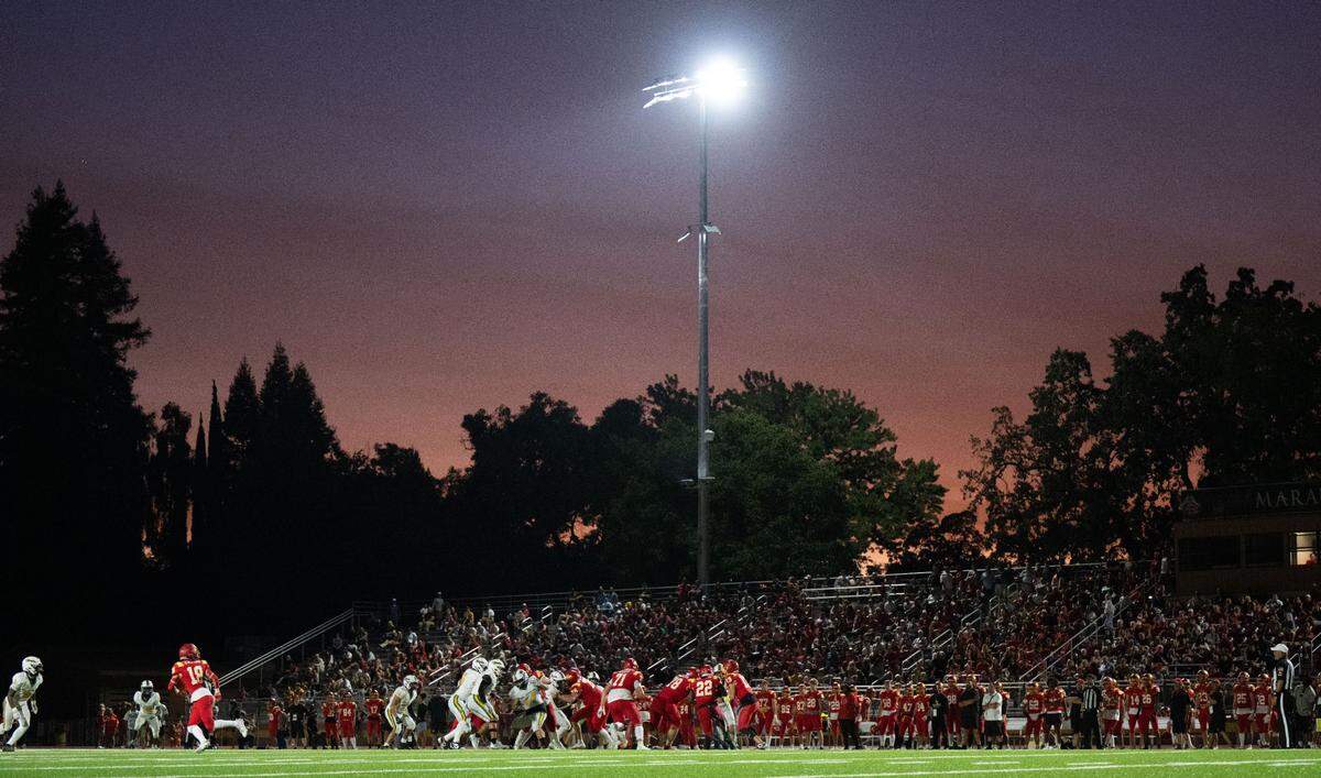 Jesuit High School’s new stadium lights shine as the sun sets while Marauders quarterback Teddy Rios (13) hands off to running back Chris Effiong Jr. (22) for a 60-yard touchdown  on Friday, Aug. 30, 2024, in Carmichael. 