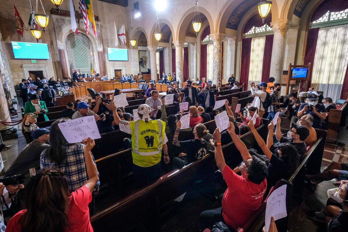 People hold signs and shout slogans as they protest before the cancellation of the Los Angeles City Council meeting Wednesday.