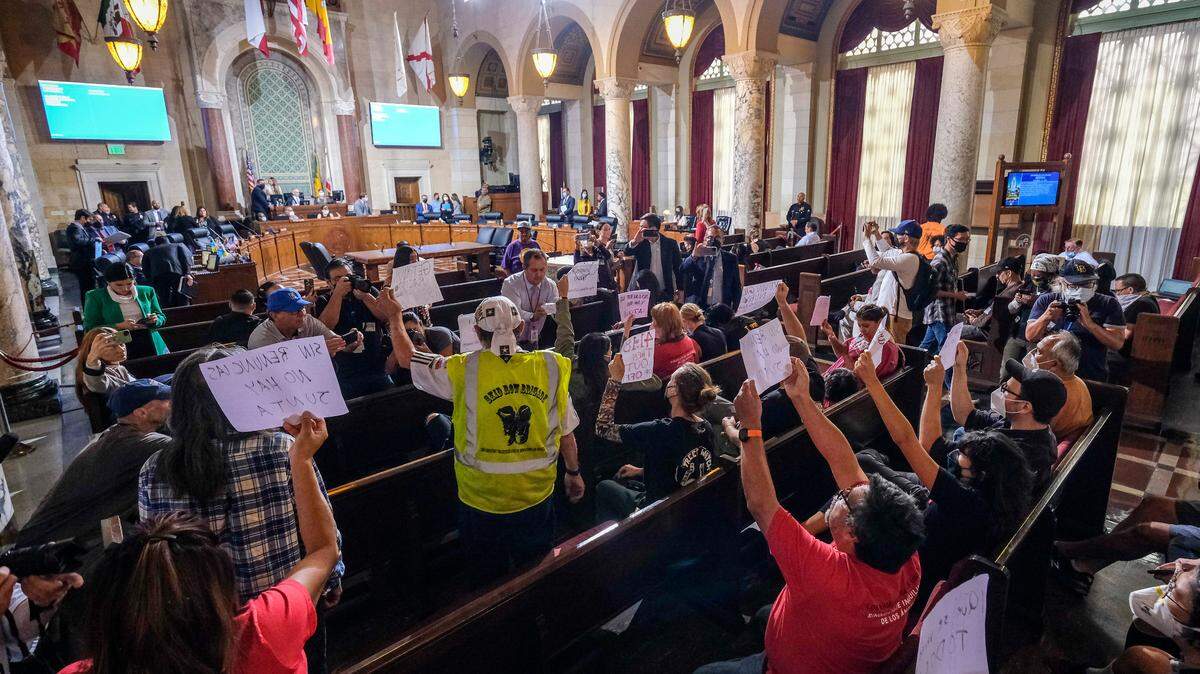 People hold signs and shout slogans as they protest before the cancellation of the Los Angeles City Council meeting Oct. 12 in Los Angeles. (AP Photo/Ringo H.W. Chiu)
