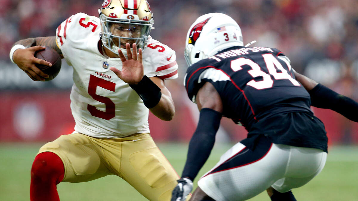San Francisco quarterback Trey Lance tries to elude Arizona free safety Jalen Thompson during Sunday’s game.