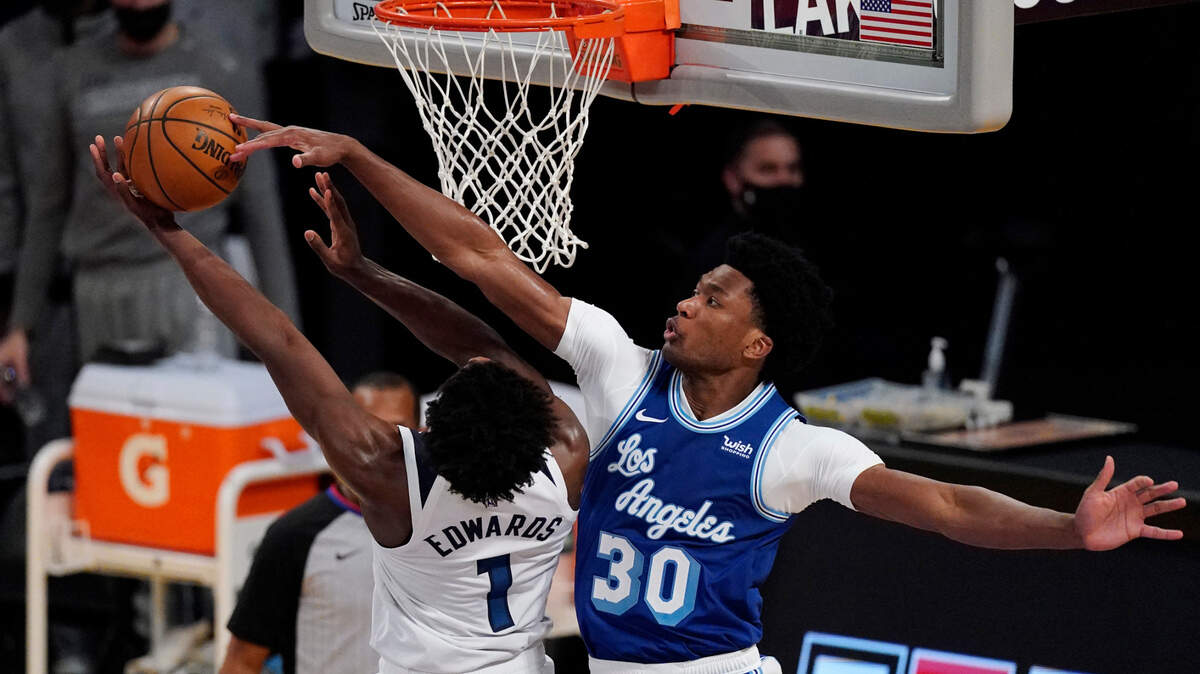 Minnesota Timberwolves forward Anthony Edwards, left, shoots as Los Angeles Lakers center Damian Jones defends during the first half of an NBA basketball game Tuesday, March 16, 2021, in Los Angeles. (AP Photo/Mark J. Terrill)