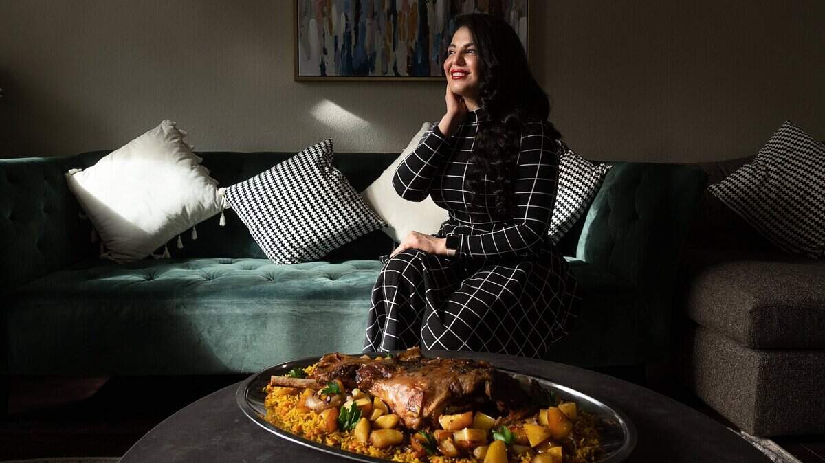 Lamees AttarBashi, a food blogger and host of a Middle Eastern cooking show broadcast on Dubais Al Sharquiya Network, sits in her Sacramento home with a traditional Iraqi dish of roasted lamb leg with carrot rice on Tuesday, Feb. 16, 2021. She is preparing to launch a snack company called Bashi’s Superfood Snacks.