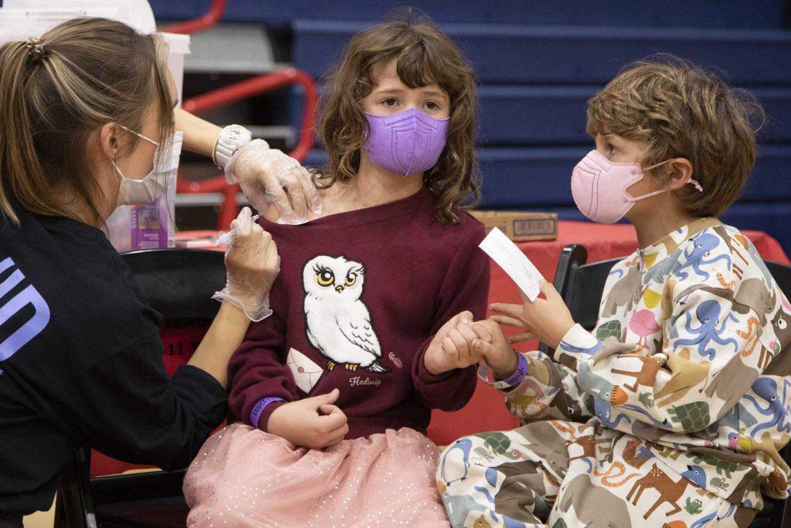 August Lopez, 6, holds his 8-year-old sister Ruby’s hand as she gets her COVID-19 vaccine at Arleta High School in Los Angeles on Nov. 8. The World Health Organization designated a new variant of concern, omicron, Nov. 26, 2021.