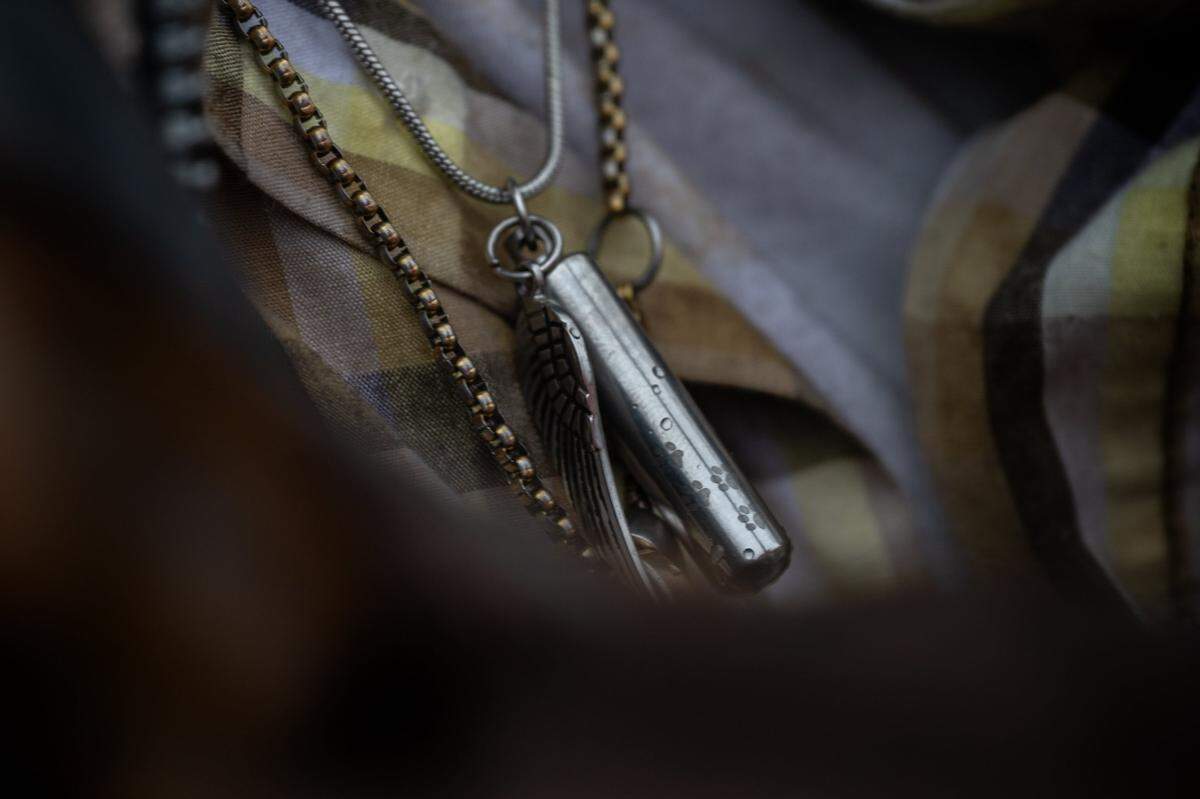 Phillip Minton wears the ashes of Lady Bug, the dog he raised with his beloved partner Wendy Connell, around his neck. He plans to wear a similar necklace with the ashes of Connell, who was killed in January when she was struck by vehicle while riding her bike.