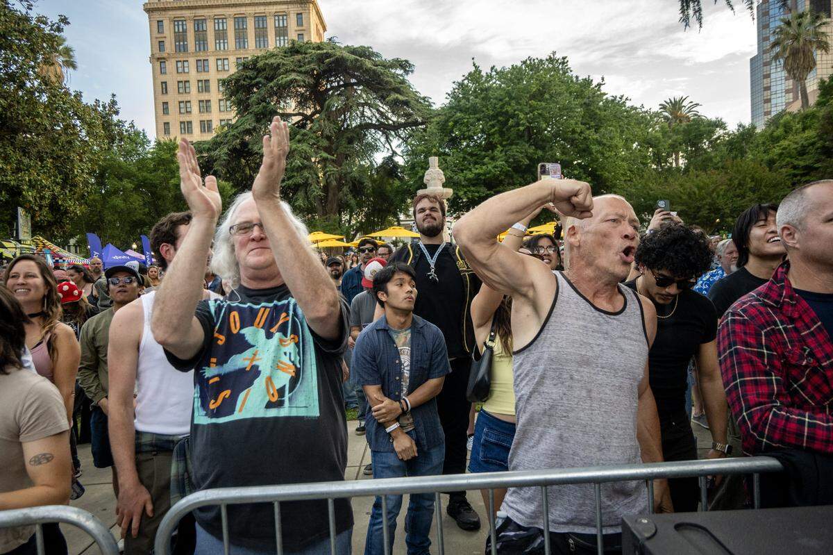 Bryan Nelson, left, and Dennis Farrell cheer as Ashley Jaguar finishes their set at Concerts in the Park across from Sacramento City Hall on Friday.