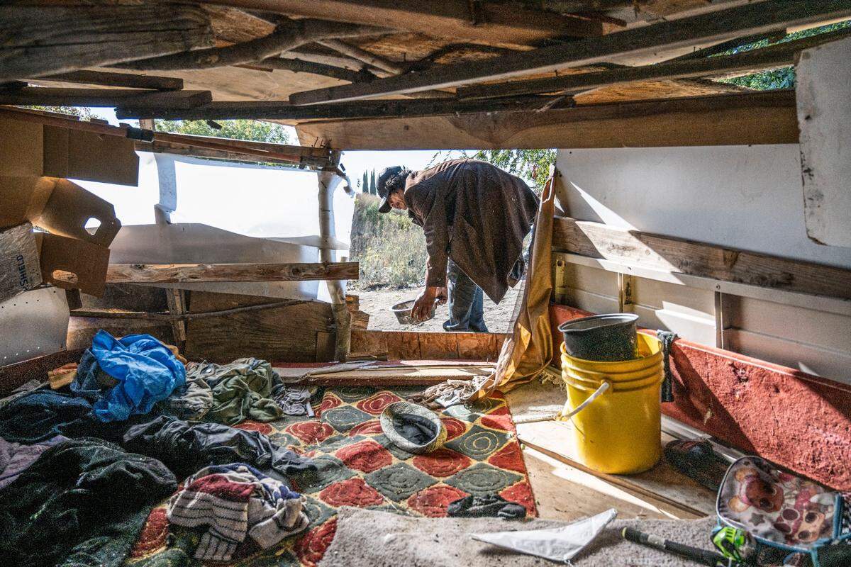 Joy Siriboutxong, 48, climbs down from a temporary structure that he and his brothers lived in on Morrison Creek in south Sacramento on Oct. 6 before the Department of Utilities demolishes the homeless encampment to begin levee work. Siriboutxong and his brothers gathered whatever belongings they could carry with them before heavy duty equipment destroyed the structure.