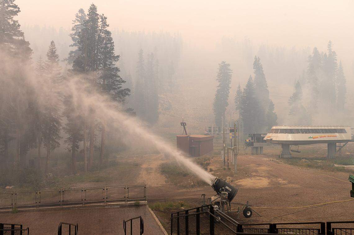 A snow blower shoots water at the Sierra-at-Tahoe ski resort on Monday, Aug. 30, 2021, after the Caldor Fire burned through the area. The resort escaped major damage.