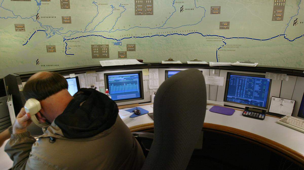A Department of Water Resources employee monitors reservoir operations at the State Water Project operations control center in Sacramento in 2006, the last time The Bee was allowed to photograph the room. The data displays on the wall map have been retired in favor of digital screens.