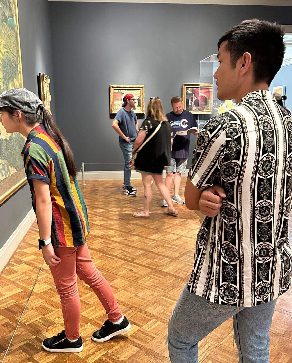 Rafi, (right) observes his sister, (left), at an art museum. The two are immigrants from Afghanistan.
