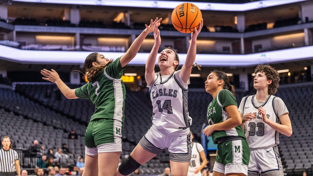 The Vista del Lago Eagles’ Ella Skrzyniarz (14) goes to the basket as she’s defended by the Manteca Buffaloes’ Taimane Tuuga (2) during the CIF Sac-Joaquin Section Division III girls basketball section championship game on Wednesday at Golden 1 Center.
