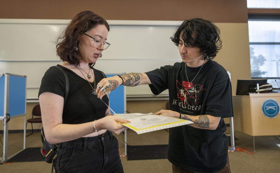 Ottillie Erick gets help from her husband, Brandon, as they vote at Folsom Lake College on Tuesday.