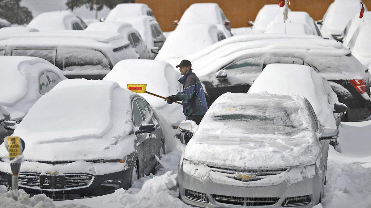 Leo Brunori, 37, of Union Dale, Pa., an employee for Hornbeck Chevrolet, in Forest City, Pa., clears away ice and snow in a frozen parking lot of used vehicles on Monday. Two women clearing snow off cars in Guelph, Ontario, got into a fight Jan. 9, police say.
