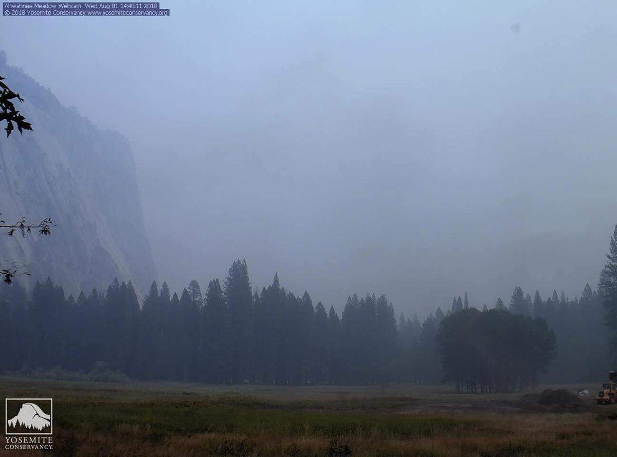 In this Wednesday, Aug. 1, 2018 image from a Yosemite Conservancy webcam, smoke from wildfires obscures the Ahwahnee Meadow at Yosemite National Park, Calif. Yosemite National Park could reopen its scenic valley and other areas Monday, Aug. 6, 2018, if conditions improve after a 12-day closure due to nearby wildfires. The park’s iconic cliffs have been shrouded in so much smoke that the air quality in Yosemite is currently worse than Beijing. (Webcam by Yosemite Conservancy via AP)