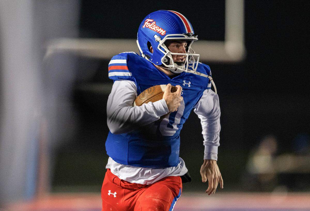 Folsom Bulldogs quarterback Brody Rudnicki (10) rushes down the sideline for 50 yards against the Riordan Crusaders In a CIF Northern California Regional Division 1-AA football championship game in Folsom on Friday.