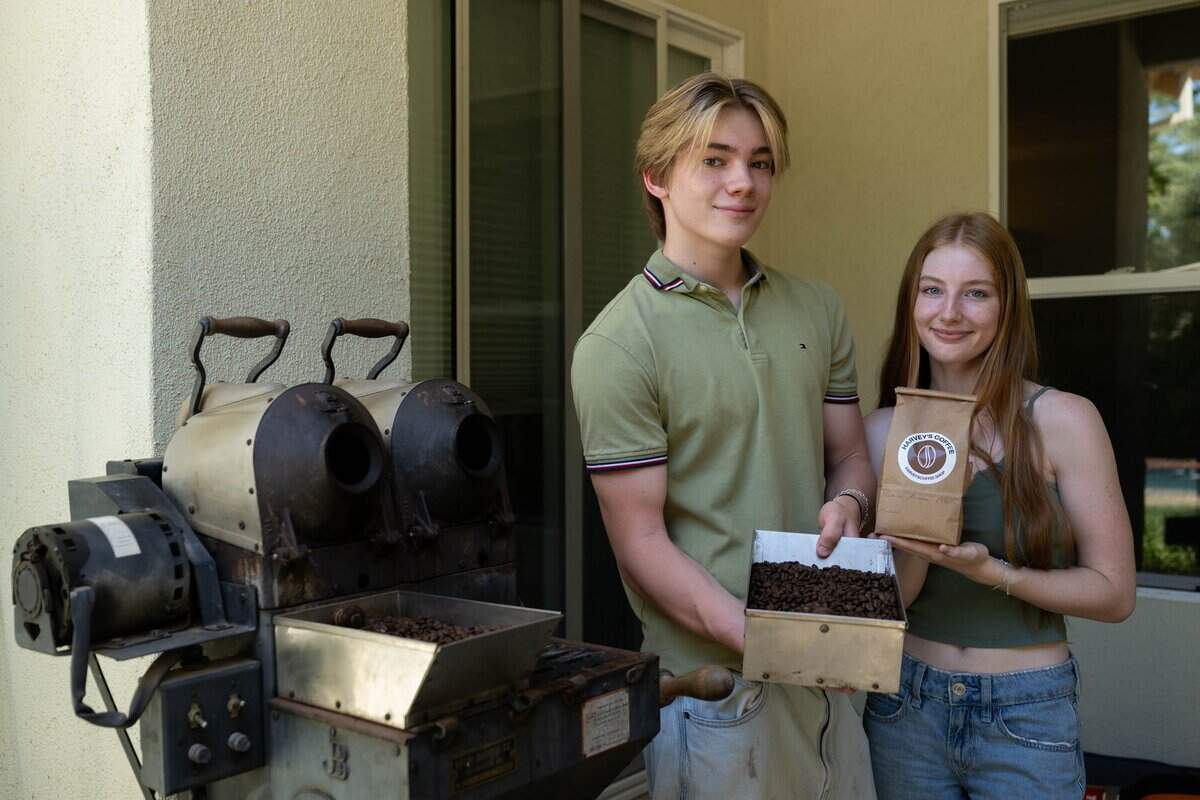 Harvey Uyeyama holds a bin of Honduras Reserva Pacavita coffee beans after roasting them in a vintage roaster dating to the early 1900s with business partner Abby Merchant at Harvey's Coffee in Davis in June.