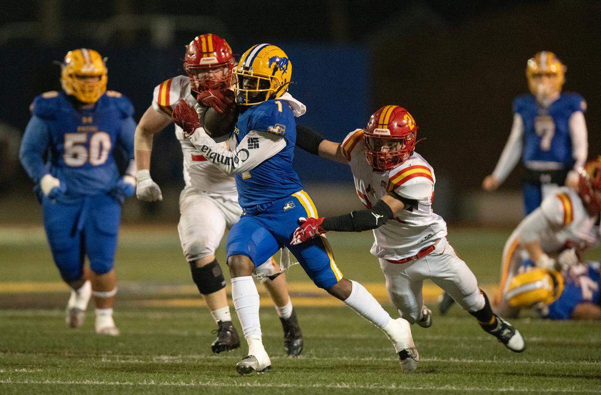 Grant Pacers running back Wayshawn Parker (1) escapes the Oakdale Mustangs’ Jackson Gilton (24) to pick up a first down during the second quarter of a CIF Sac-Joaquin Division III semifinal game on Friday, Nov. 17, 2023, at Grant High School in Sacramento.