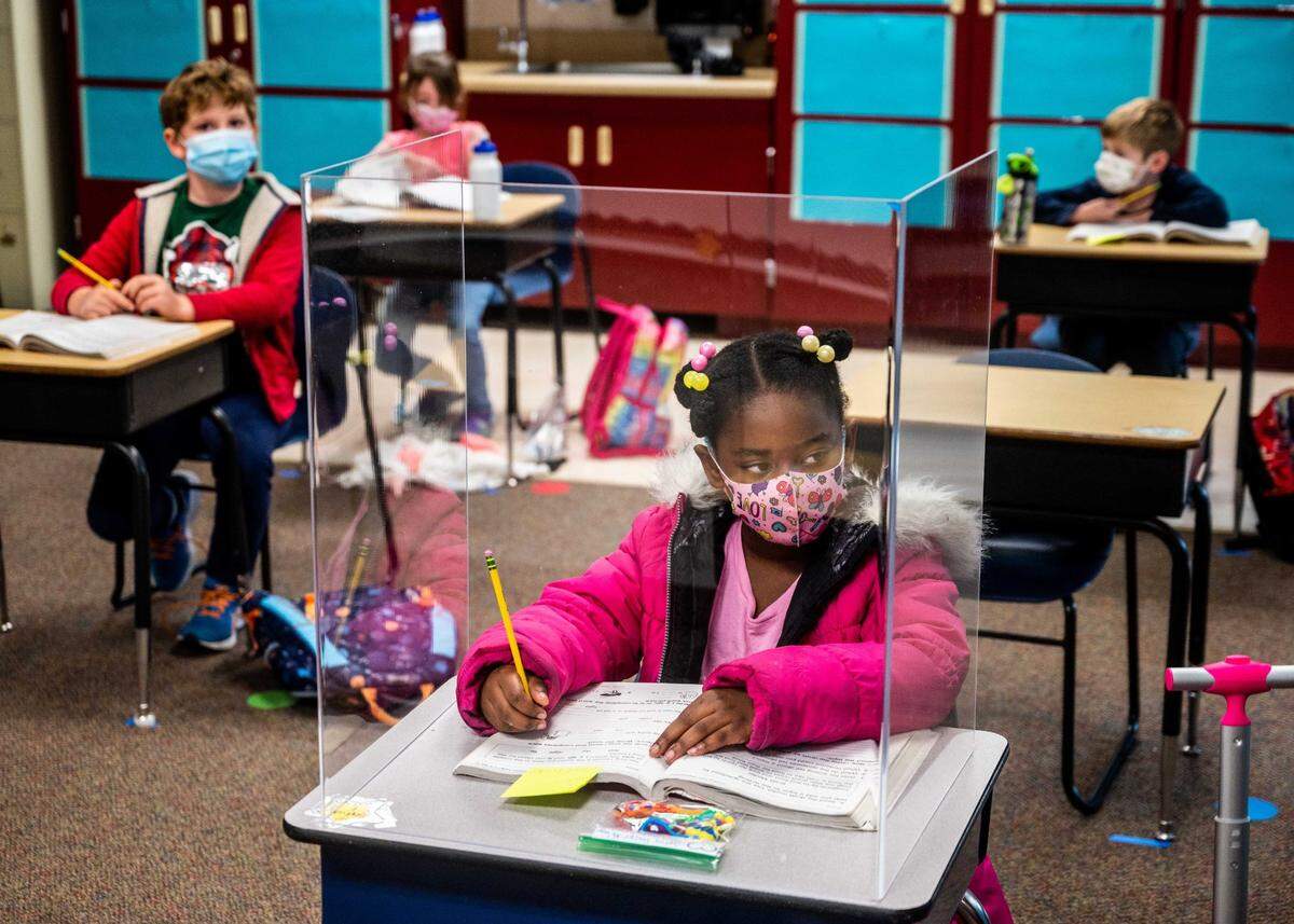 First grader Sophia Frazier does her schoolwork behind a plastic divider – only the students near the teacher’s desk seemed to have them – during class at Two Rivers Elementary School on Monday, March 8, 2021. It was the first day in class at the school for third through fifth graders, but the first graders returned last week.