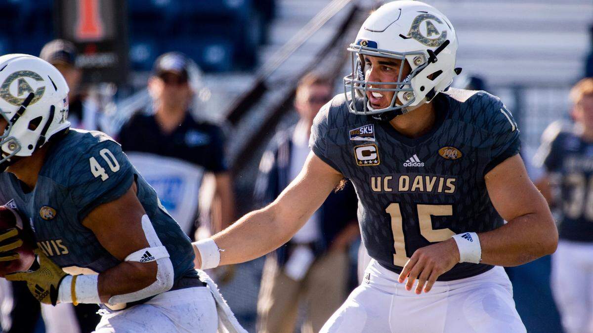 UC Davis Aggies quarterback Jake Maier (15), hands the ball off to UC Davis Aggies running back Ulonzo Gilliam (40), during the 65th Causeway Classic football game between the Sacramento State Hornets and the UC Davis Aggies at Mackay Stadium at the University of Reno, Saturday Nov 17, 2018. The game was moved there due to the bad air quality in Sacramento due to the Camp Fire.